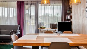 Ein modernes Wohnzimmer mit einem Holzesstisch, einem grauen Sofa und einem Fernseher auf einem Schrank.
