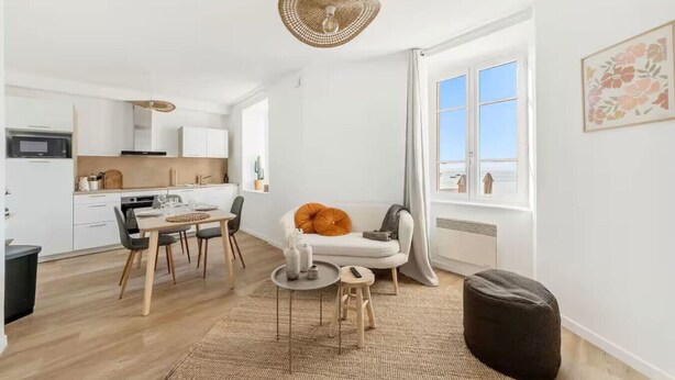 Ein modernes Apartment mit Essbereich, Küche und einem großen Fenster mit Blick.