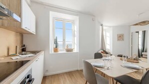 Eine moderne Küche mit Essbereich, einem großen Fenster und Meerblick.