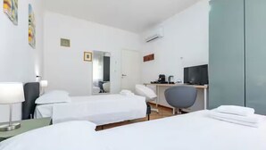 A hotel room with two beds, a desk with a computer, a chair, a TV, and a mirror. - Private room in Mestre with direct bus to Venice (ve)