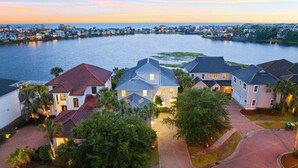 A residential area with houses along a waterfront, featuring paved roads and lush greenery. - Destin to Relax (Destin)