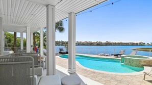 A covered outdoor area with a pool, seating, and a view of the ocean. - Destin to Relax (Destin)