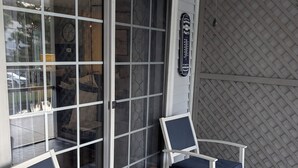 Ein überdachter Patio-Bereich mit Holztisch und zwei Stühlen, einem Deckenventilator und einem Schild, das die Verwendung von Original-Chevrolet-Ersatzteilen kennzeichnet.