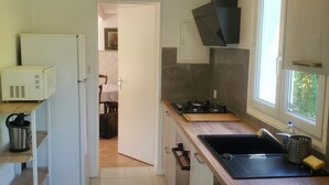 Una cocina con un lavamanos, estufa y un reloj en la pared.