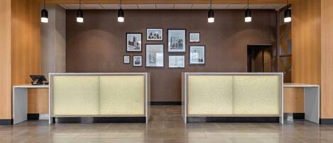 A reception area with two counters, framed pictures on the wall, and pendant lighting.