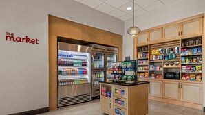A clean, well-organized store with a refrigerated section, snack shelves, and a wooden counter. - Drury Plaza Hotel Tampa Brandon (Tampa)