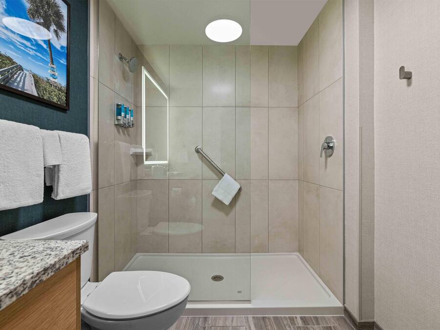 A modern bathroom with a shower, toilet, and sink.