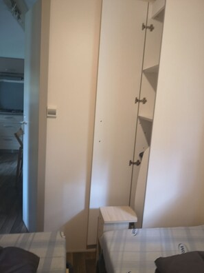 Ein Schlafzimmer mit Bett, Kleiderschrank und einem kleinen Tisch.