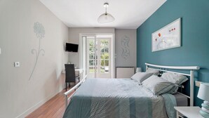 Een slaapkamer met een bed, een bureau en een stoel.