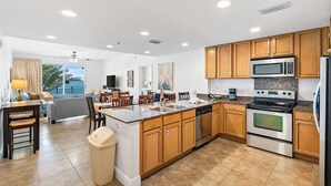 Une cuisine moderne avec des meubles en bois, des appareils en acier inoxydable et un grand îlot central.