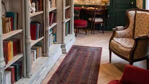A room with a bookshelf, a desk, a chair, and a patterned rug. - Maison La Louise (Ligny-en-Barrois)