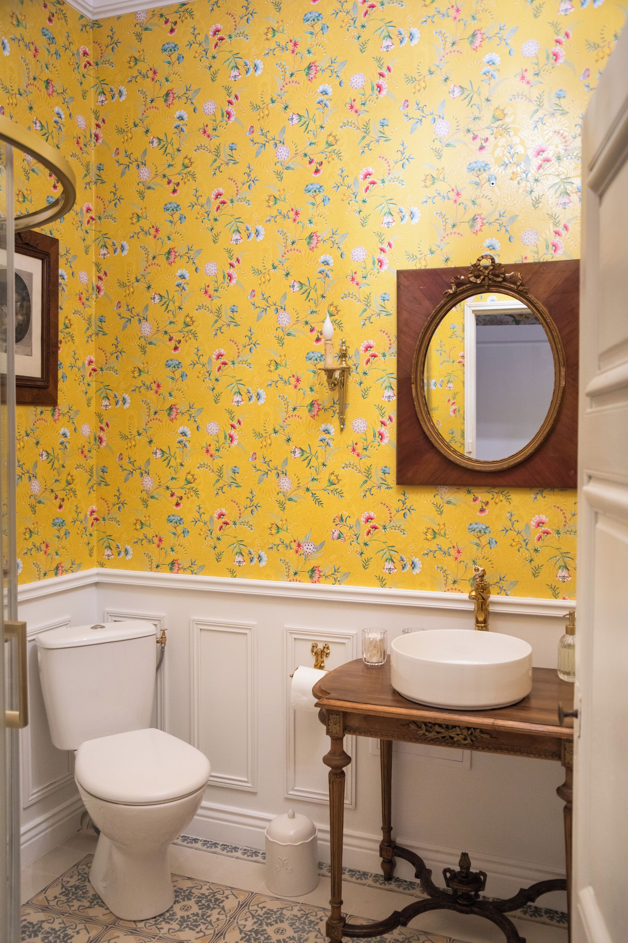 Une salle de bain avec des toilettes, un lavabo et un miroir.