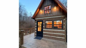 Eine Holzhütte mit Eingangstür, Fenstern und einer Veranda.