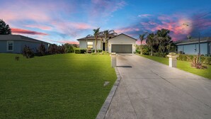 Una casa residencial con un césped cuidado, un garaje y una entrada para vehículos.
