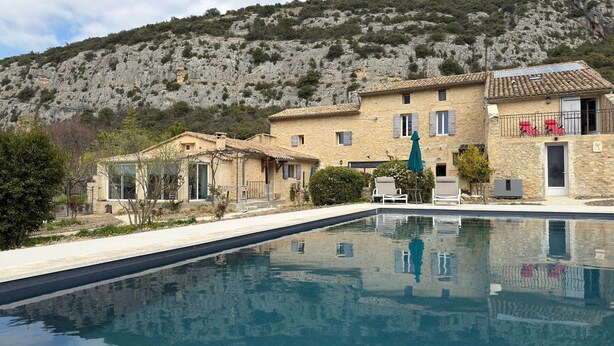 A pool with a mountain backdrop, stone buildings, and a clear sky. - Le Ventoux, gîte for 5 _ Lacets du Ventoux (Beaumont-du-Ventoux)