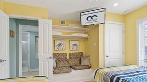 A bedroom with two beds, a sofa bed, and a sign for Ocean City Vacation Homes. - 110A Newport Bay ,Deck Seating , Pool , WaterView (Ocean City)