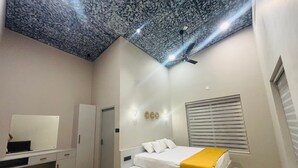 A bedroom with a bed, a desk, a wardrobe, a ceiling fan, and a window with blinds. - 5-bedroom upper house in Wayanad for a relaxing getaway (Kalpetta)