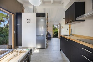 Eine moderne Küche mit Kühlschrank, Spüle und Holzarbeitsplatte.