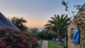 Un vialetto fiorito conduce a una zona relax con vista sul mare.