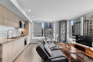 Una cocina moderna con comedor, sofá y televisor.