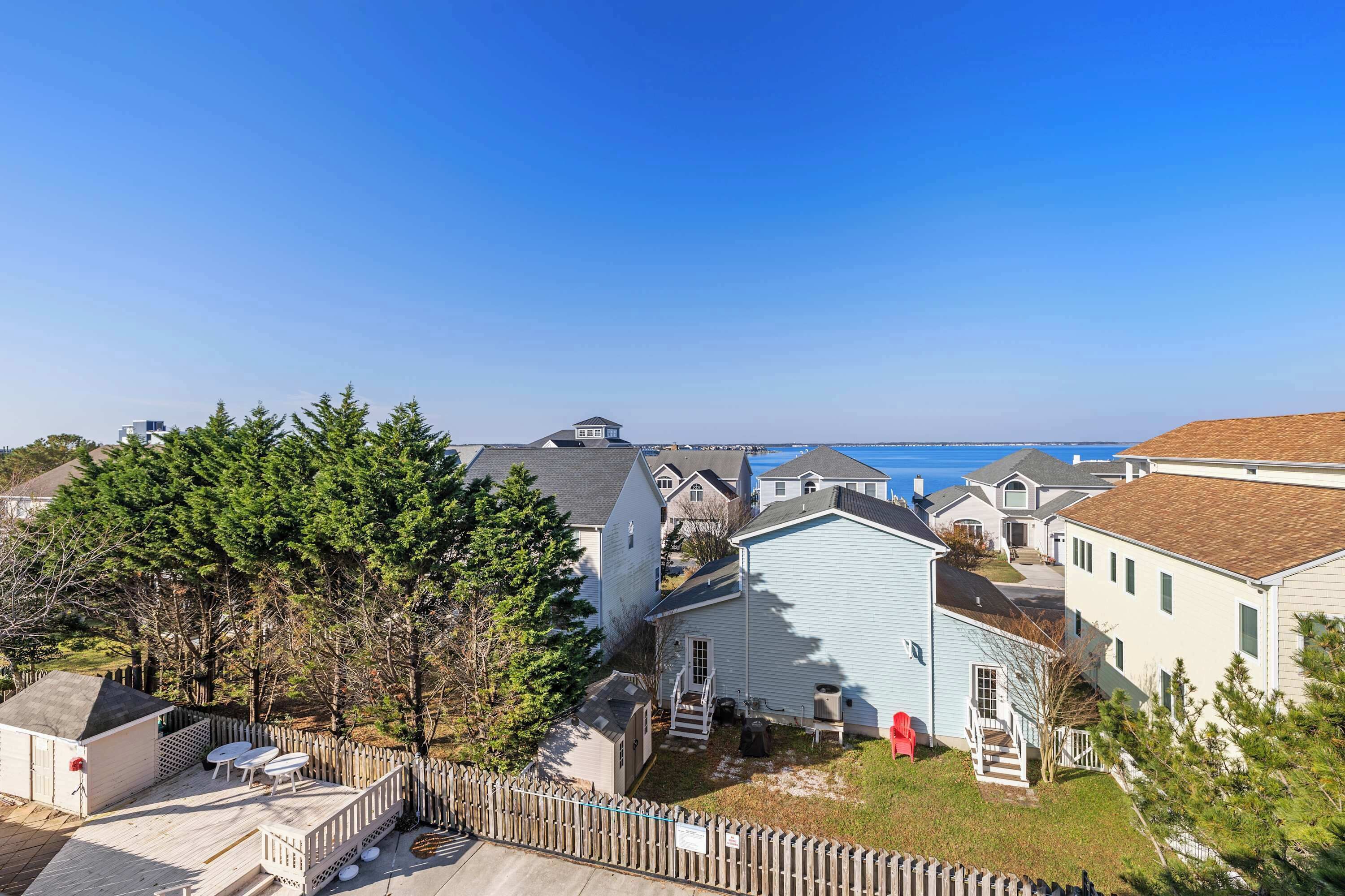 A residential area with houses, a wooden deck, and a view of the ocean.