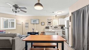 Un ambiente compatto con angolo ristoro, angolo cottura e ventilatore a soffitto.