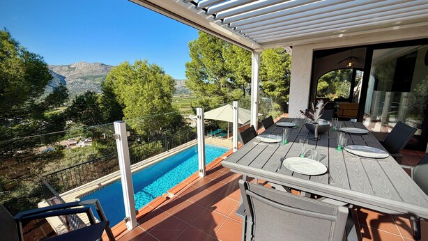 A terrace with a pool, dining area, and mountain views. - Villa Horizonte with pool and pool house, mountain and nature views (orba)