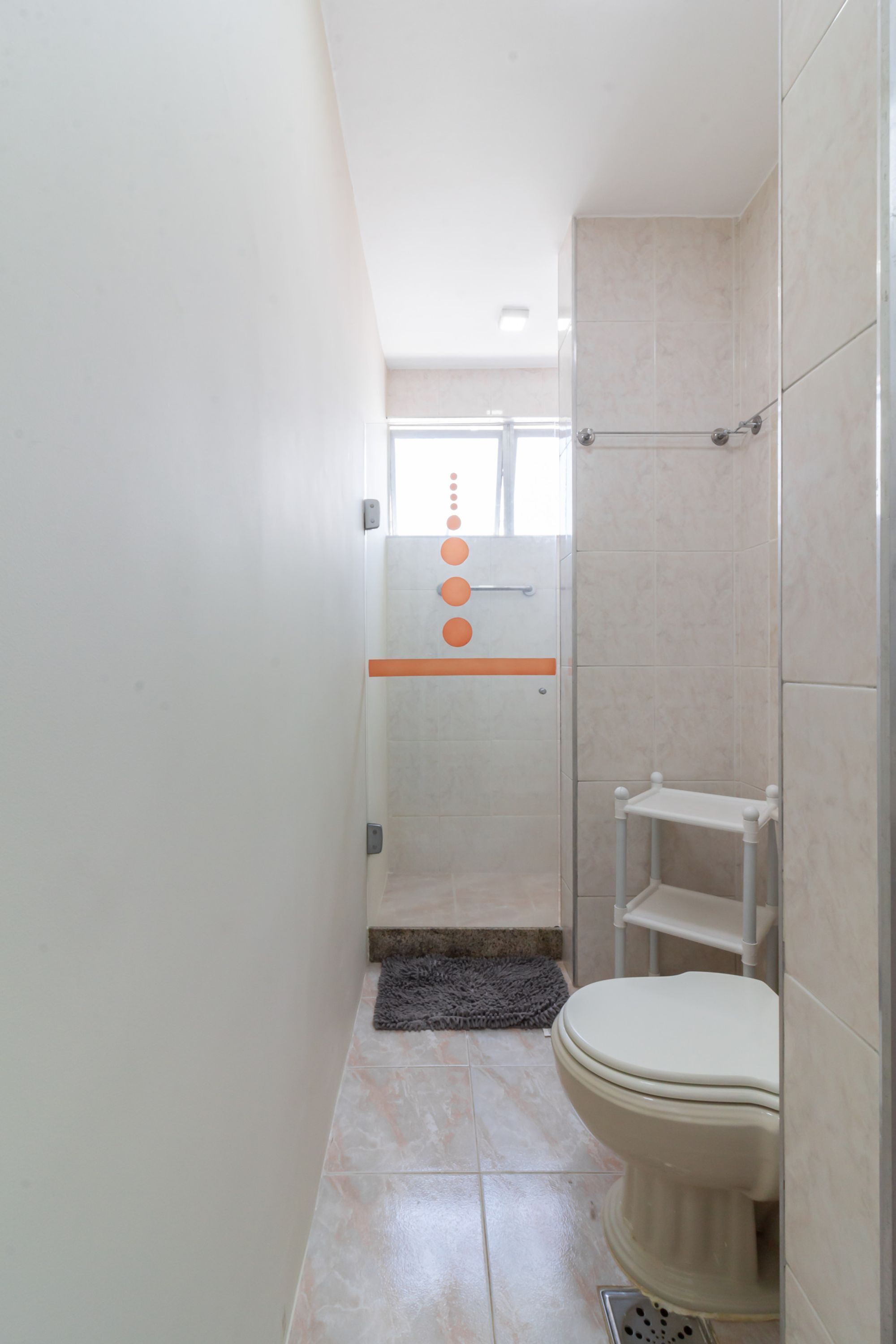 Baño con ducha, inodoro y perchero para toallas.