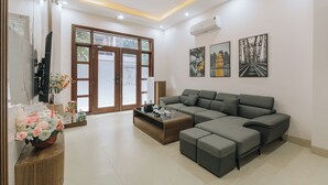 A modern living room with a sectional sofa, a coffee table, and artwork on the walls.
