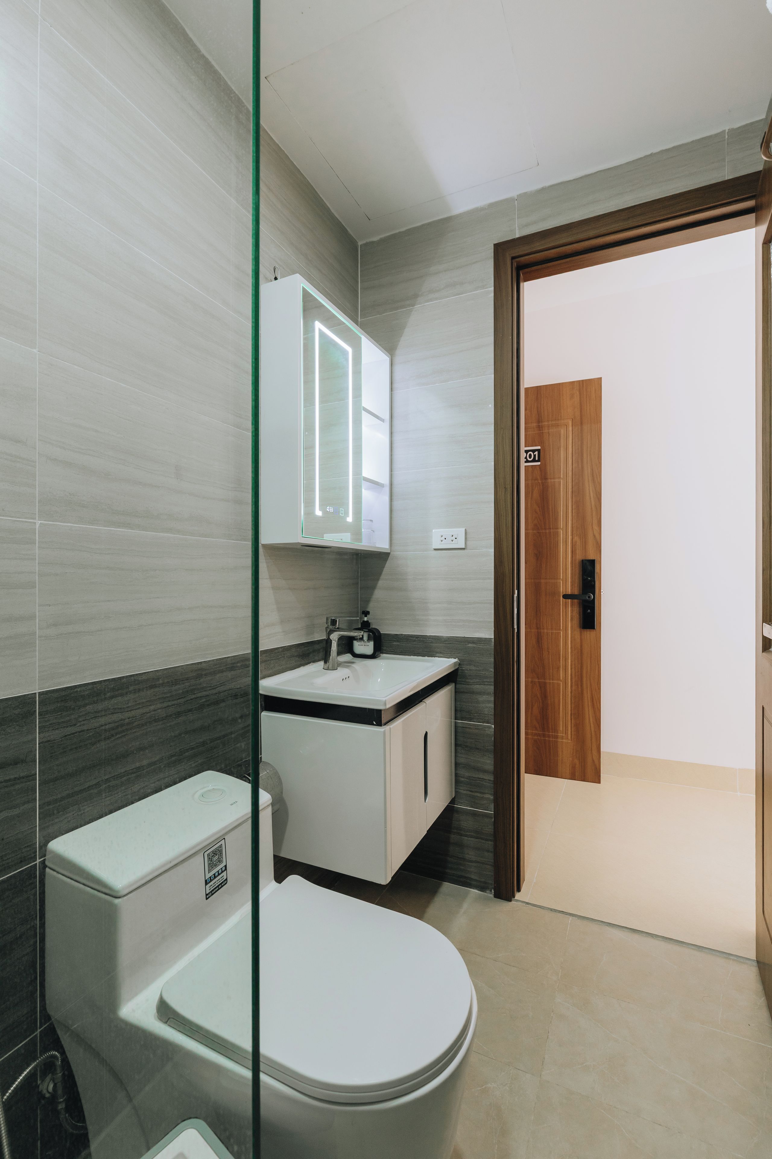 Ein modernes Badezimmer mit Toilette, Waschbecken und Spiegel.