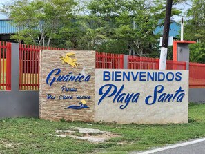 A sign with "Guánica Playa Santa" and a logo of a crab, indicating a beach location. - Dolphin Beach Villages / The Little Jungle (Guánica)