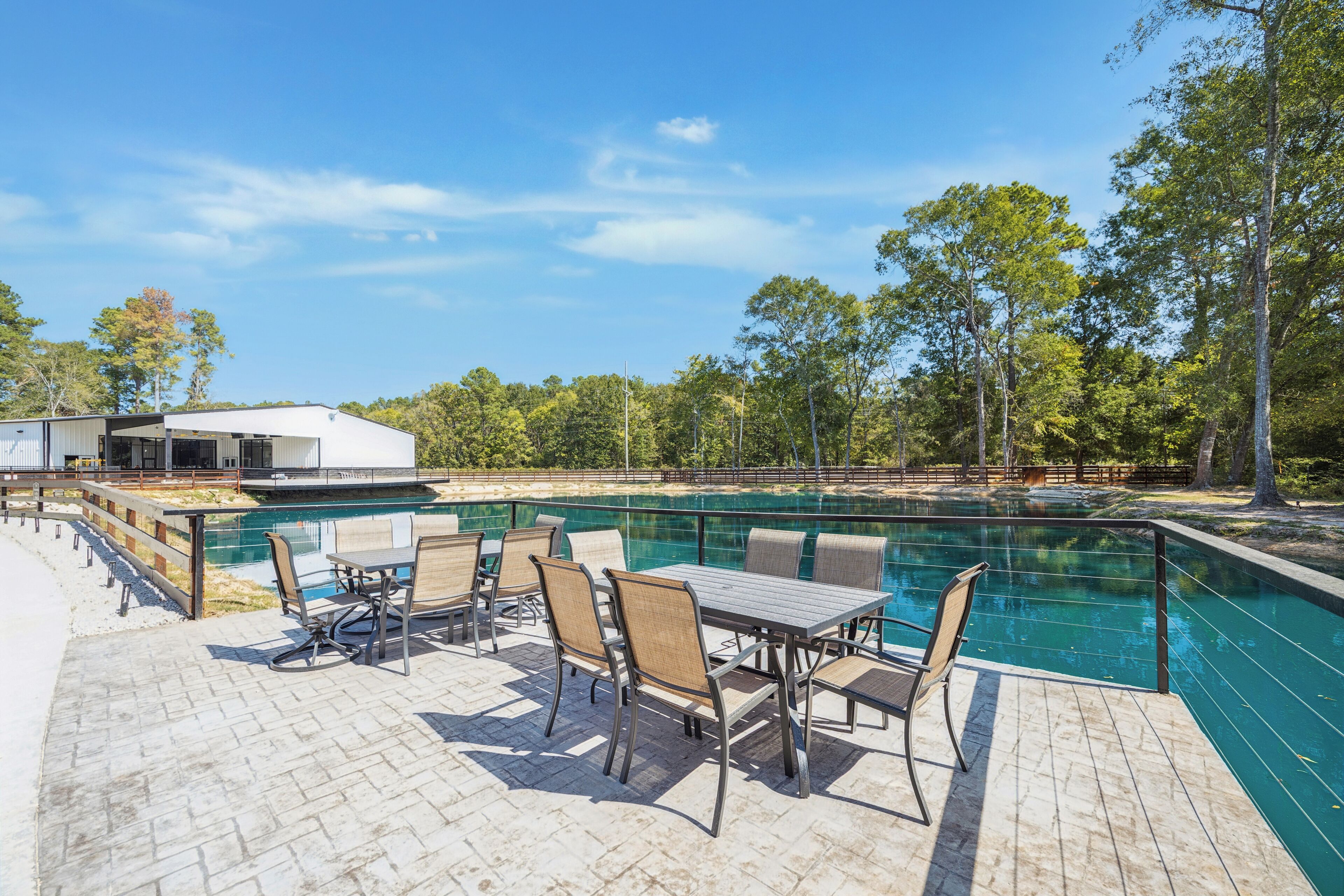 Un espace aménagé au bord de la piscine, avec une table et des chaises, un coin salon abrité et une piscine.