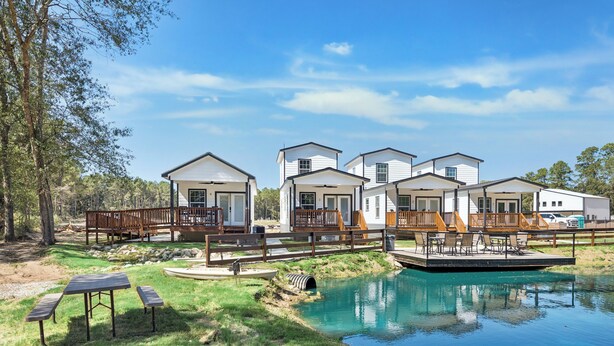 A row of white cabins with wooden decks and a swimming pool. - Everstead Cottage - Cabin 3 (Plantersville)