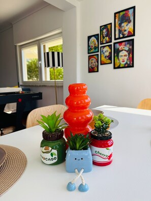 A table with potted plants and a window with blinds.