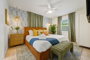 A neatly arranged bedroom with a bed, bedside tables, a ceiling fan, and a window with curtains. - Resort Style Backyard  Pool  Hot Tub  Movie Room (Seminole)