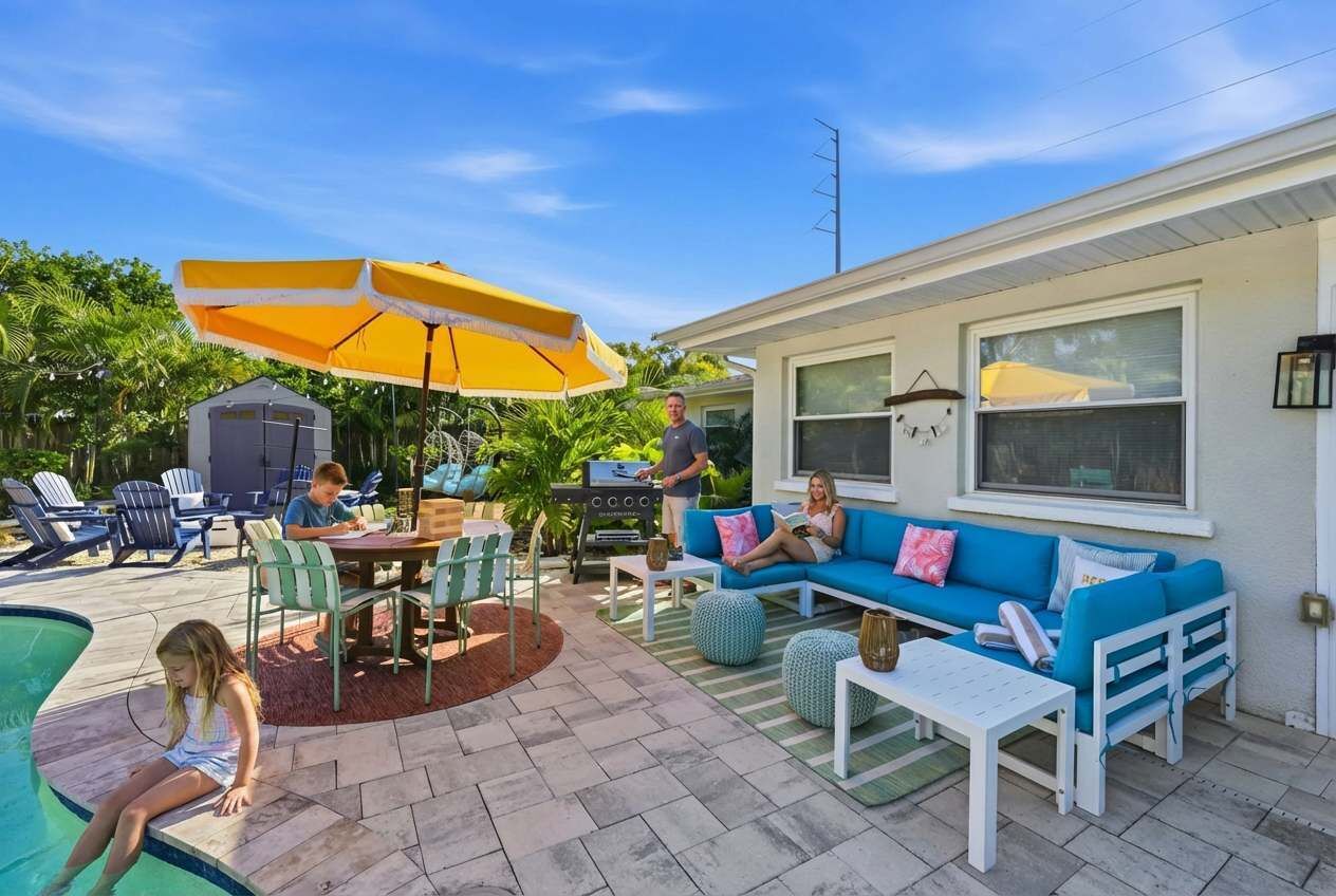 Eine Terrasse mit Gartenmöbeln, einem Grill und einem Swimmingpool.