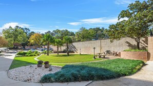 Zona exterior amb jardí, un camí pavimentat, bancs i una taula de pícnic.