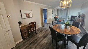 A dining area with a wooden table and chairs, a chandelier, and a framed picture on the wall. - Hampton Oaks Hideaway (Columbia)