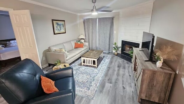 A modern living room with a sofa, coffee table, and fireplace. - Hampton Oaks Hideaway (Columbia)