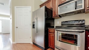 A kitchen with a stainless steel refrigerator, a microwave, and an oven. - Classy 3 br Townhouse (Lexington County)