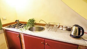 A kitchen with a gas stove, stainless steel sink, and a coffee maker. - CHARMING ROOFTOP FLAT IN CITY CENTER (Catania)