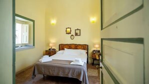 A hotel room with a bed, two bedside tables, a window, and wall-mounted lights. - CHARMING ROOFTOP FLAT IN CITY CENTER (Catania)