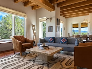 A spacious living area with a sofa, armchairs, a coffee table, and a view of the outdoors. - Casa de Azulejos (Santa Fe)