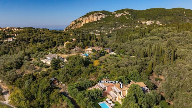 An aerial view of Villa Koumquat surrounded by dense greenery and hills. - Villa Koumquat by Villa Plus (Paleokastritsa)