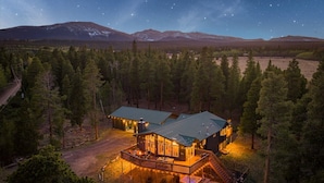 Un lodge con un'ampia terrazza, una vasca idromassaggio e lo scenario di una montagna.