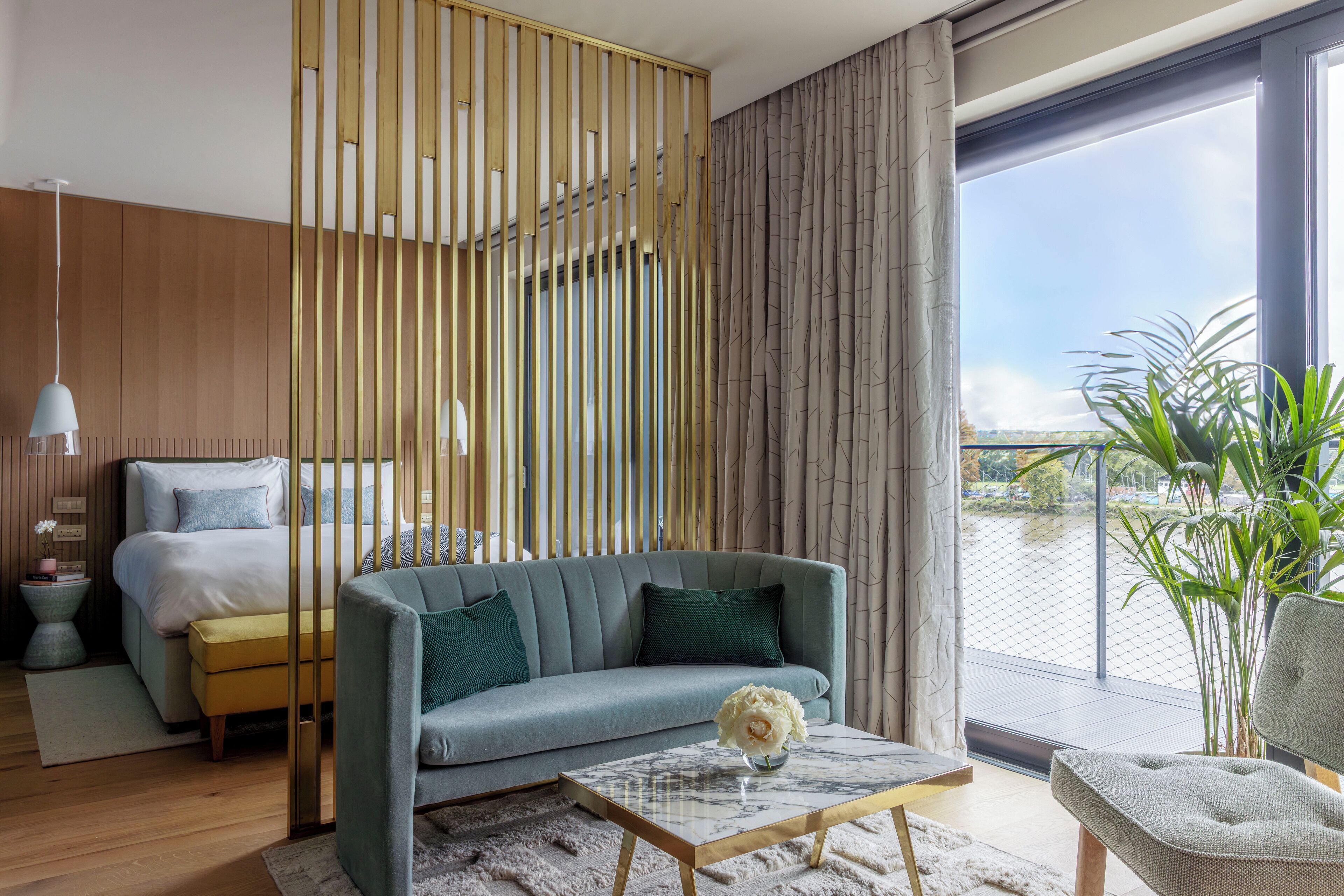 A modern living room with a sofa, a coffee table, and a view of a balcony.