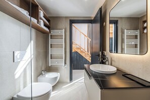 Un baño moderno con lavamanos doble, inodoro y toallero.