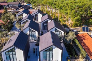 Una zona residencial moderna con varias casas que tienen techos geométricos y ventanas amplias.
