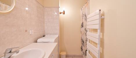 Ein Badezimmer mit Waschbecken, Toilette, Dusche und Handtuchhalter.