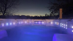 A swimming pool with a central water feature and surrounding lights. - Wine Country Farmhouse (Culpeper)